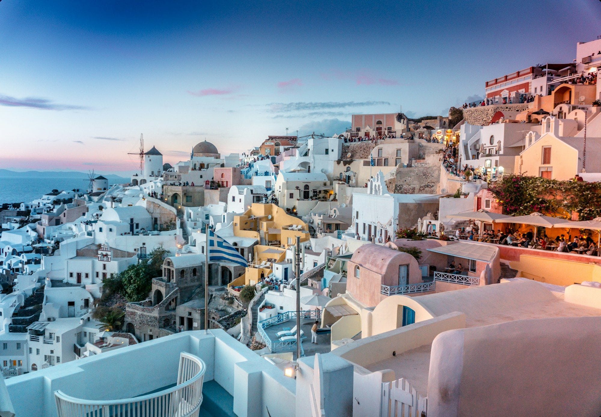 Whitewashed cliffside village overlooking the Aegean at dusk